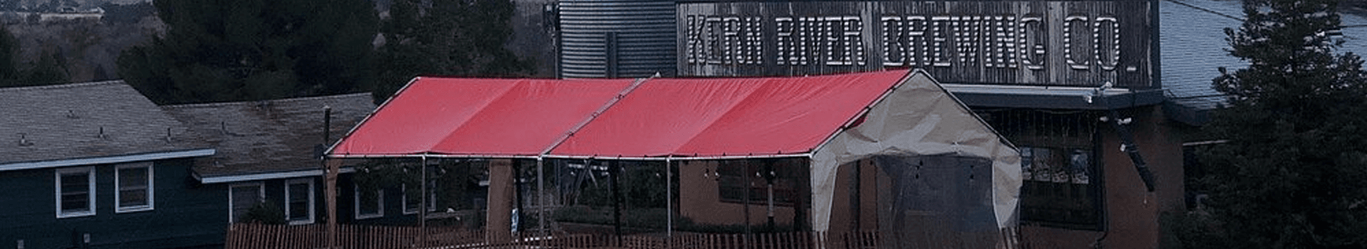 A red canopy covers an outdoor seating area at Kern River Brewing Company.