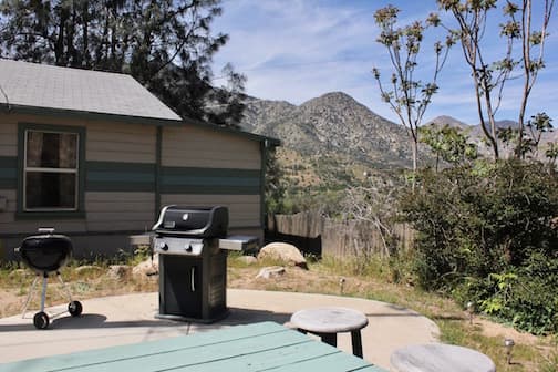 A backyard patio with a grill and mountain views.